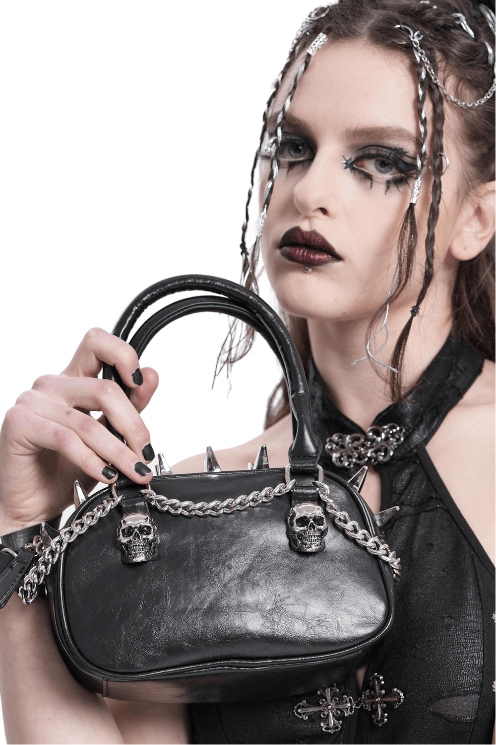 Gothic punk skull handbag with spikes and chain, worn by model for edgy alternative fashion.