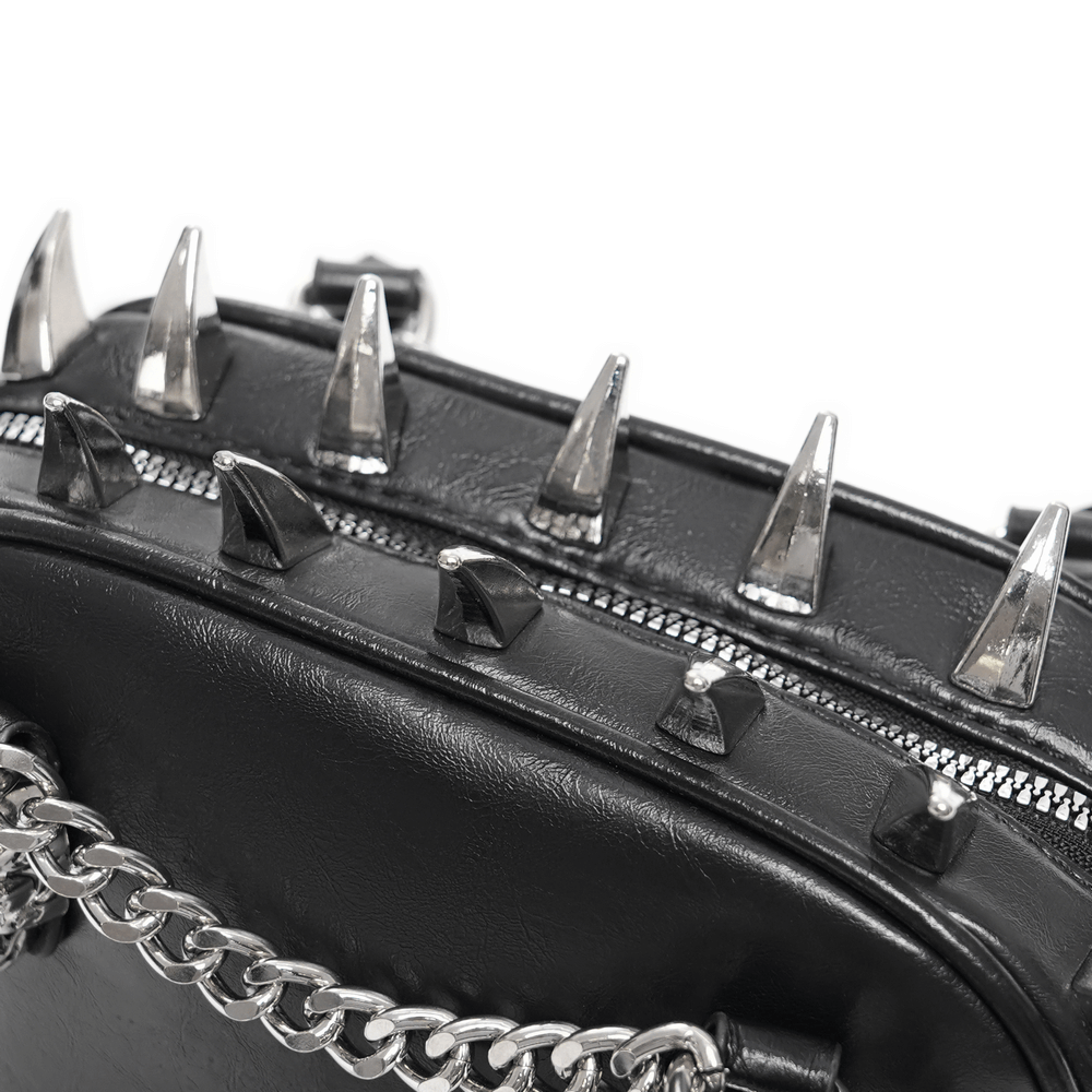 Close-up of gothic punk handbag showing silver spikes, zipper, and chain strap for alternative fashion.