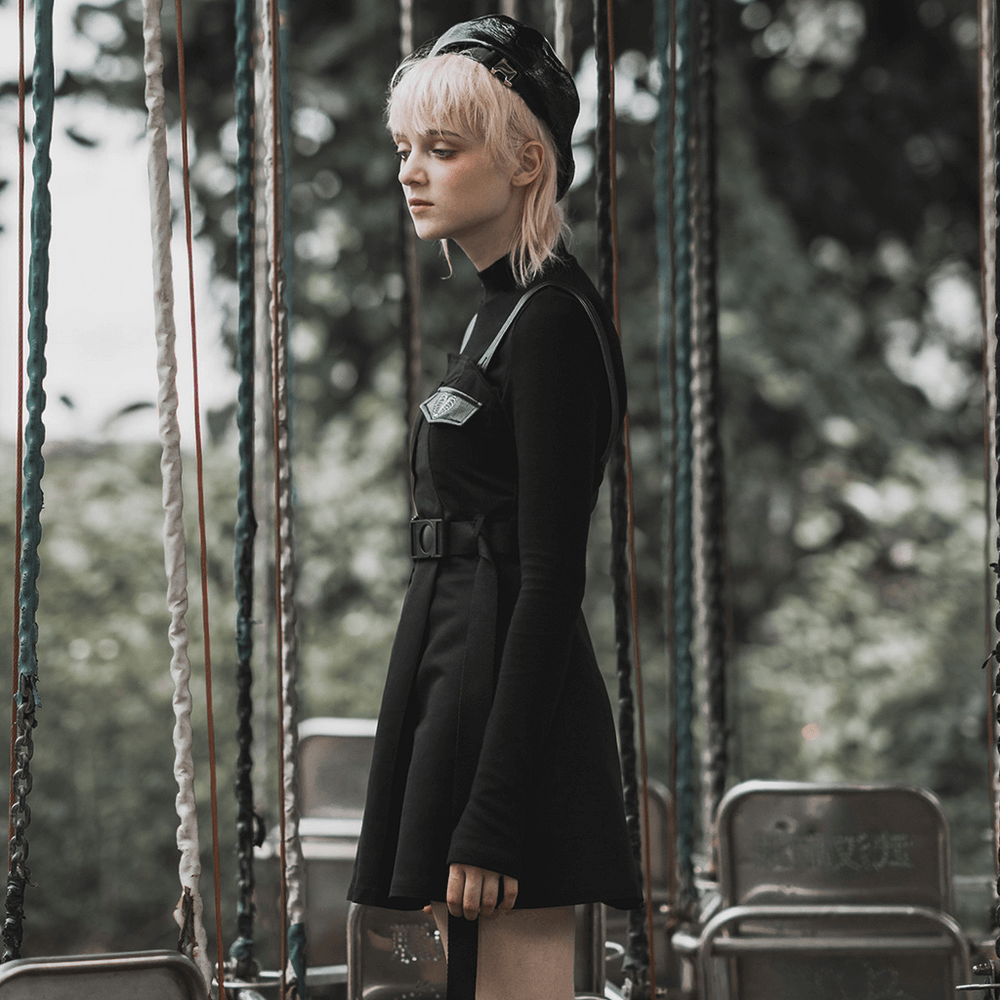 Gothic punk sleeveless dress with belt, featuring edgy style and unique collar, worn by model in a swing set background.