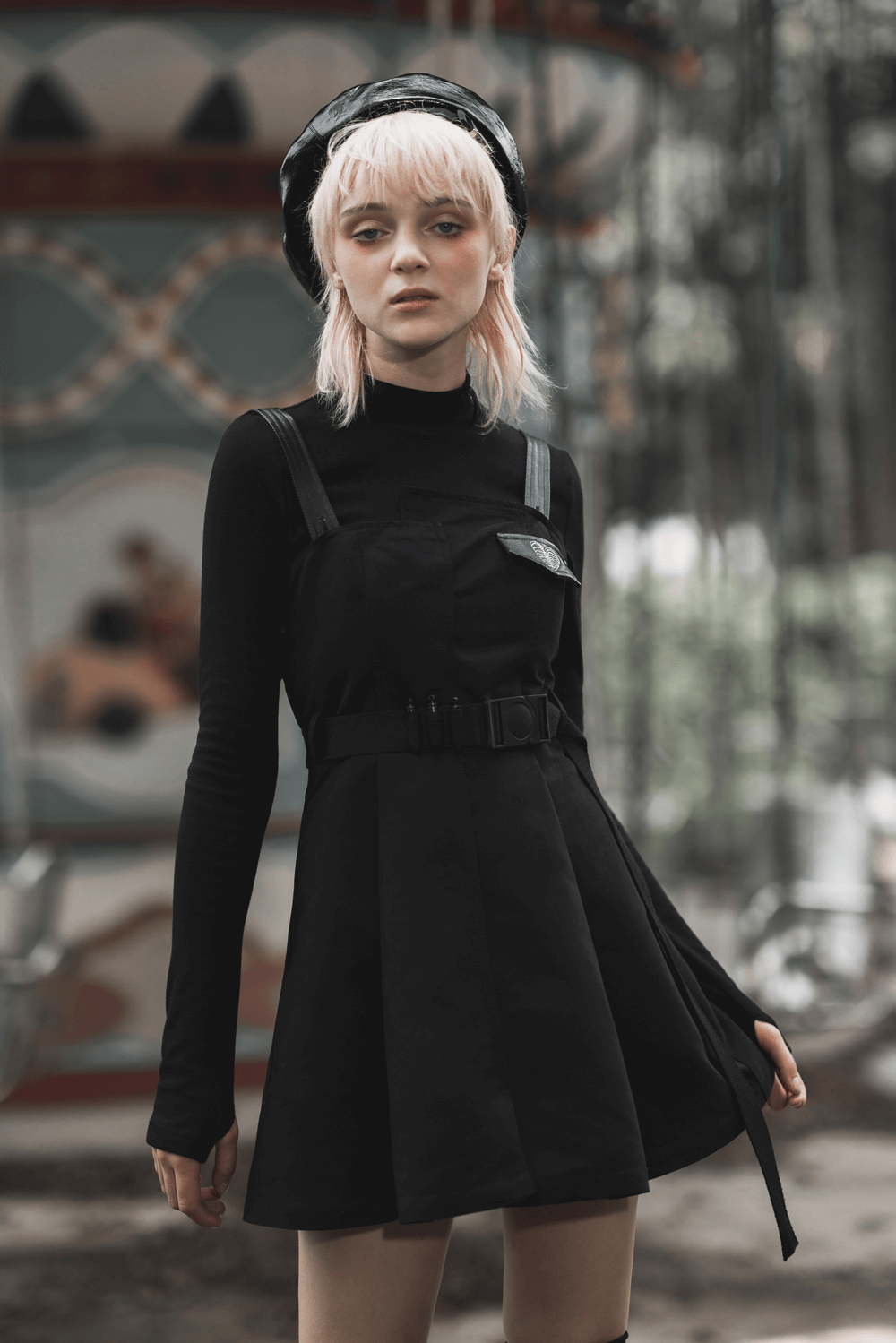 Gothic punk sleeveless dress with belt and embroidery worn by model in a moody setting.