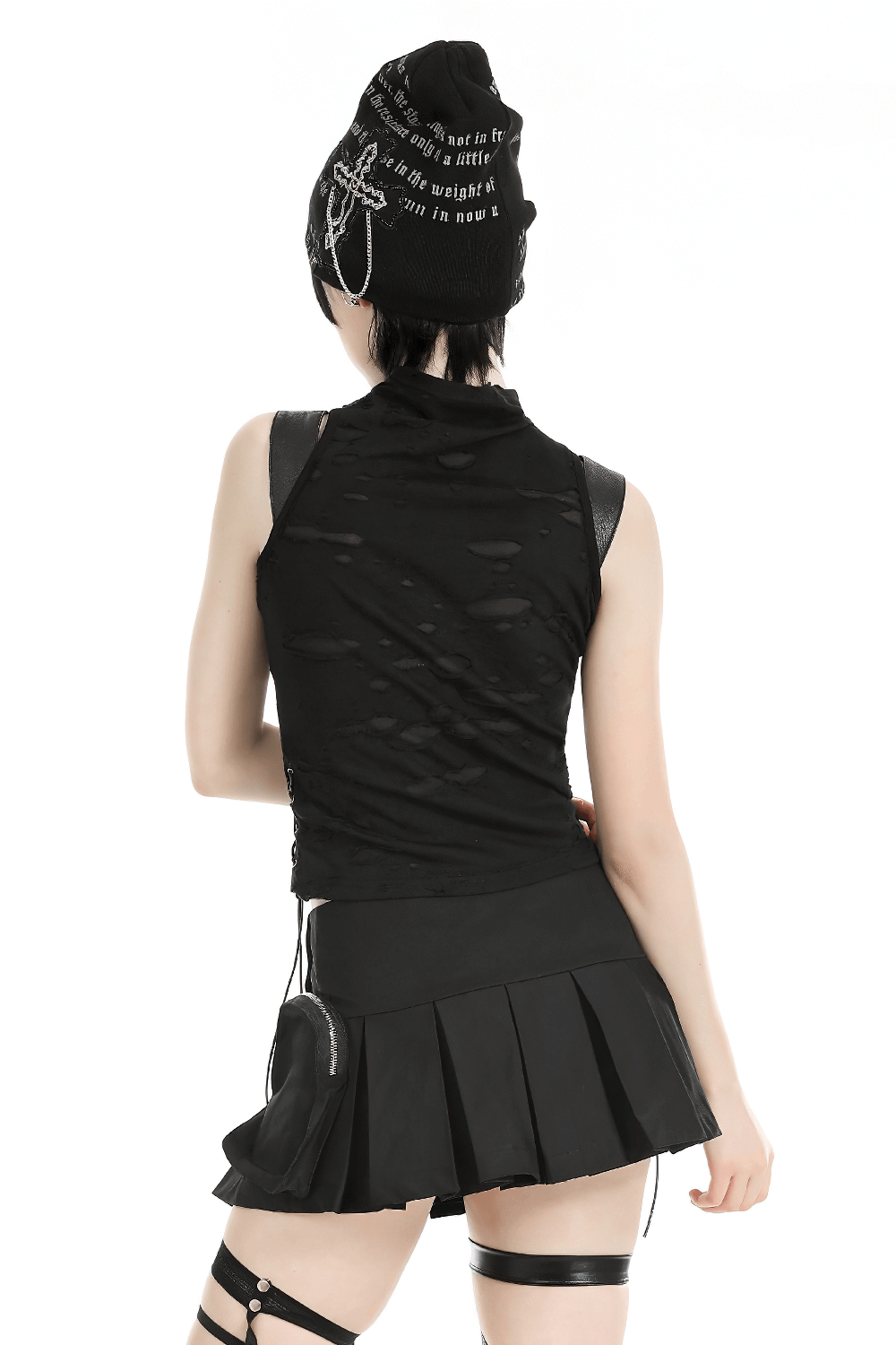 Edgy black sleeveless ripped top with buckle straps, paired with a flared mini skirt and a trendy beanie.