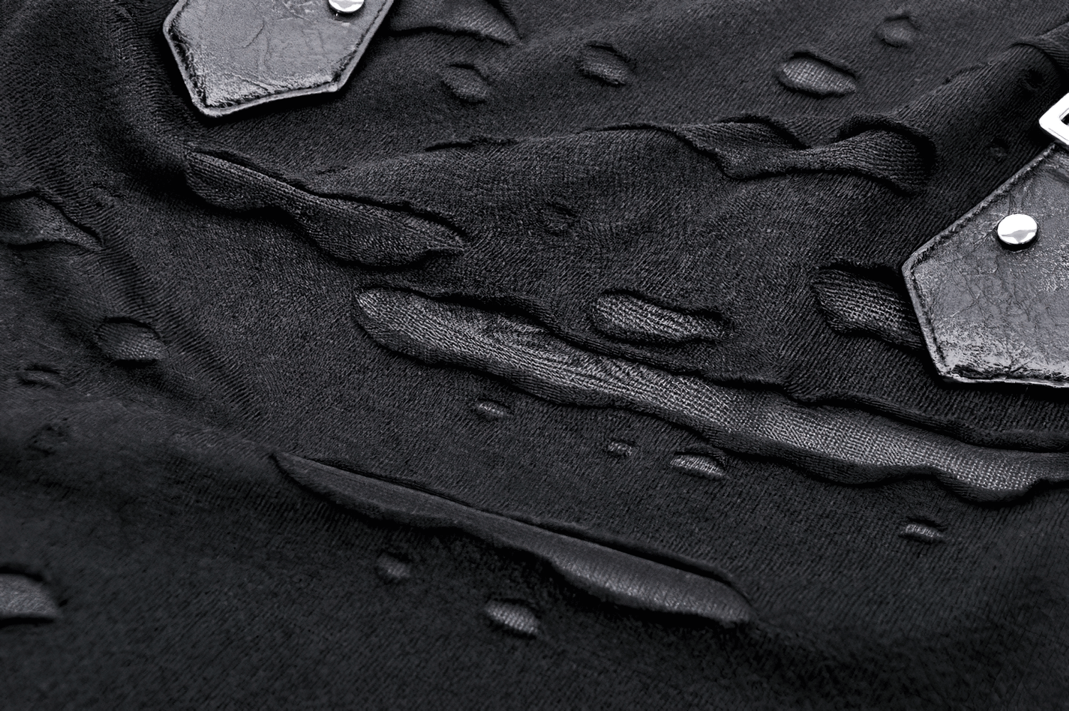 Close-up of black gothic punk sleeveless top showing unique ripped detailing and buckle straps.