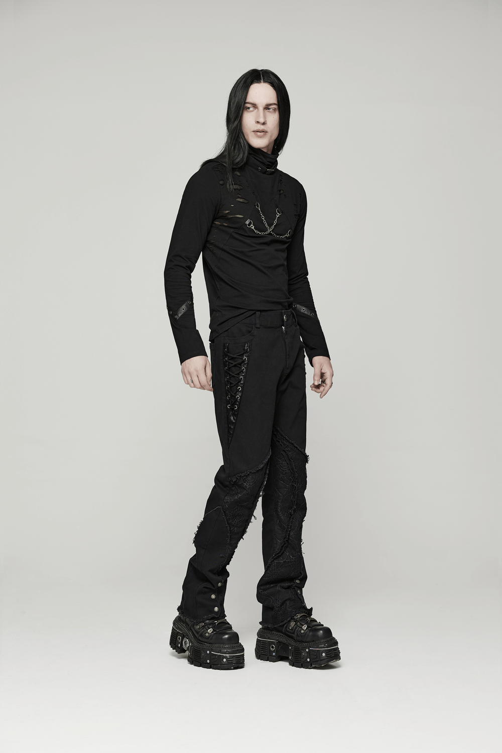 Gothic punk model showcasing spider mesh paneled pants with eyelets and rugged style in urban fashion.
