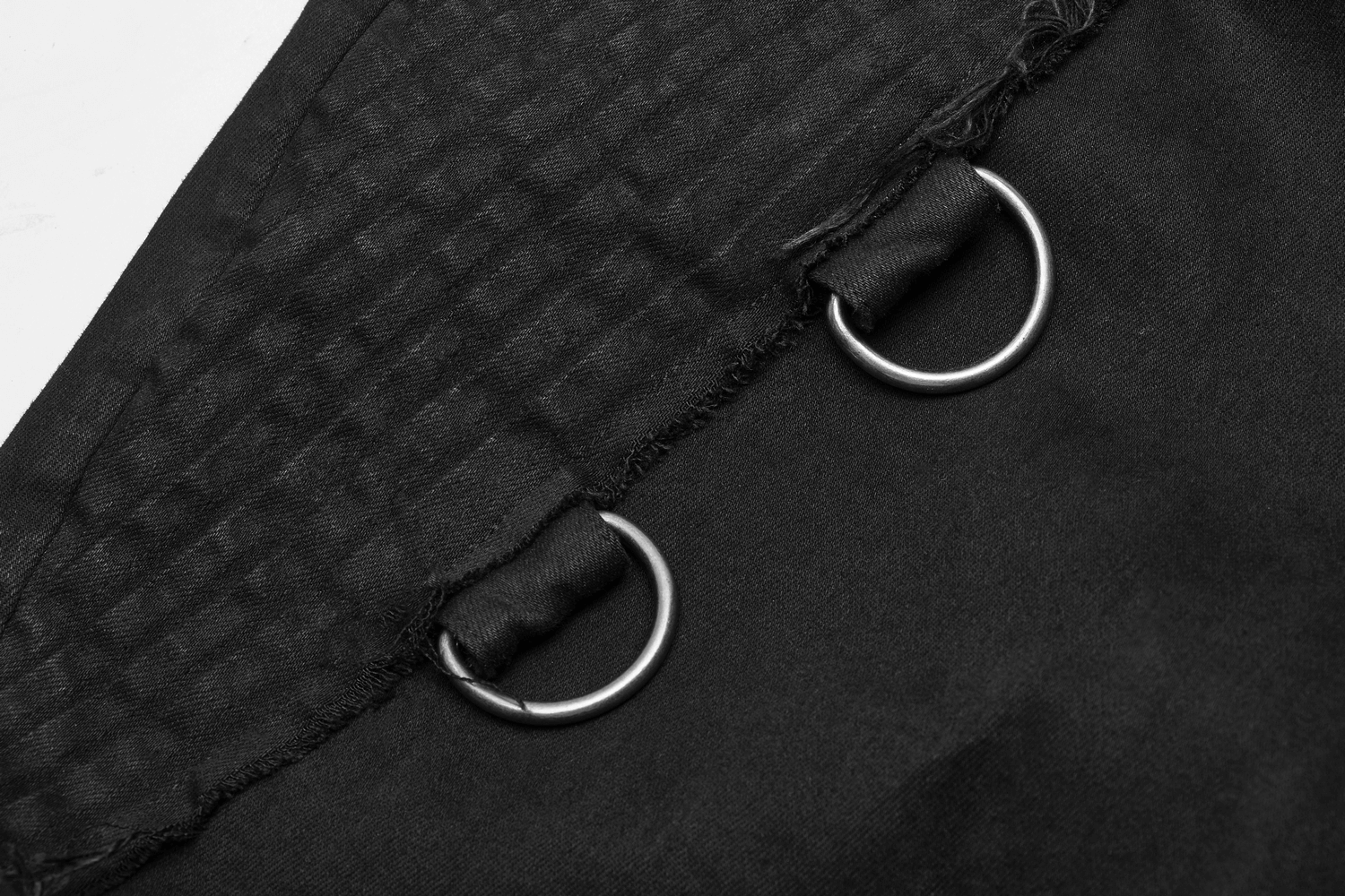 Close-up of Gothic Punk-Style black cargo pants with metal chain rings and textured fabric details.