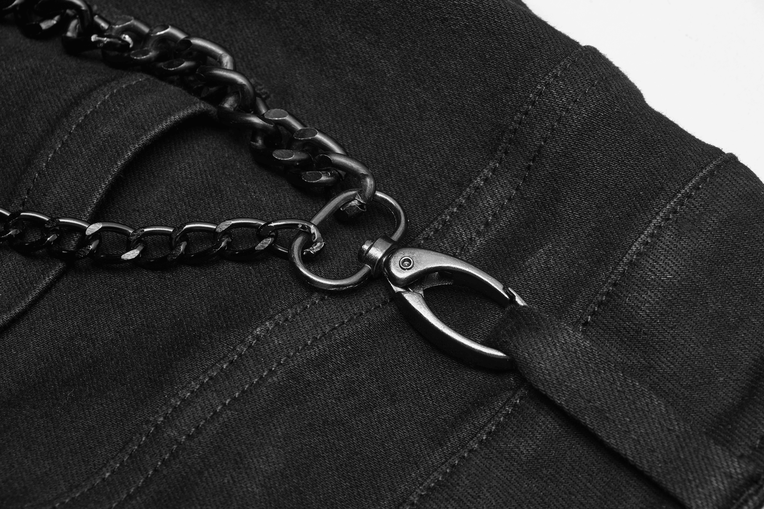 Close-up of Gothic punk-style black cargo pants with metal chain and clasp detail.
