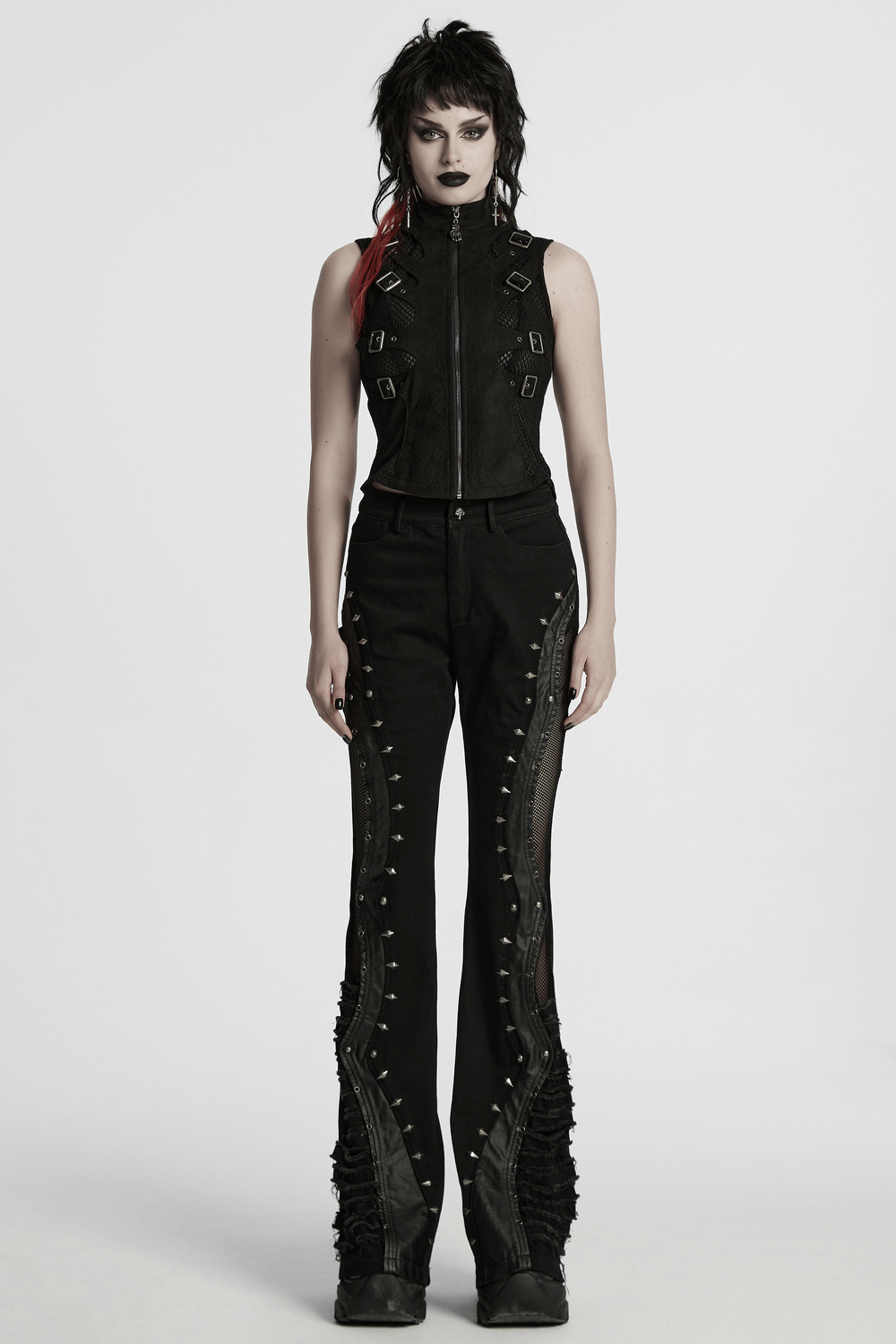 Gothic punk model wearing a suede buckle vest and edgy black pants with metallic accents, styled for a rebellious vibe.
