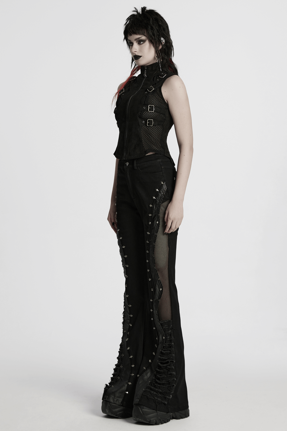 Gothic punk model in a suede vest with skeleton cutouts and edgy black pants, showcasing rebel style and personality.