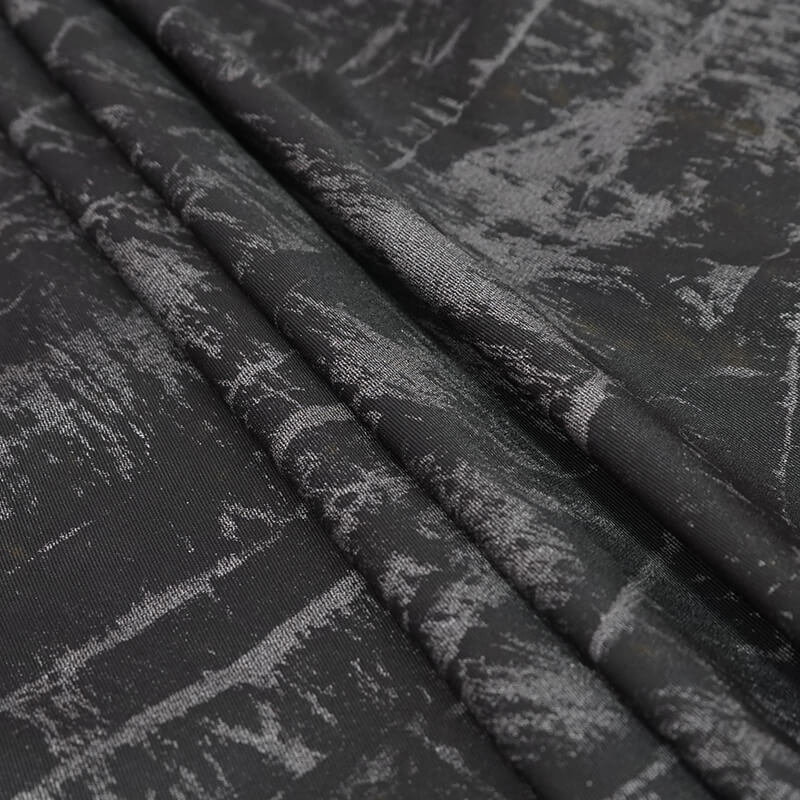 Close-up of textured black fabric with artistic gray patterns, perfect for gothic punk fashion.