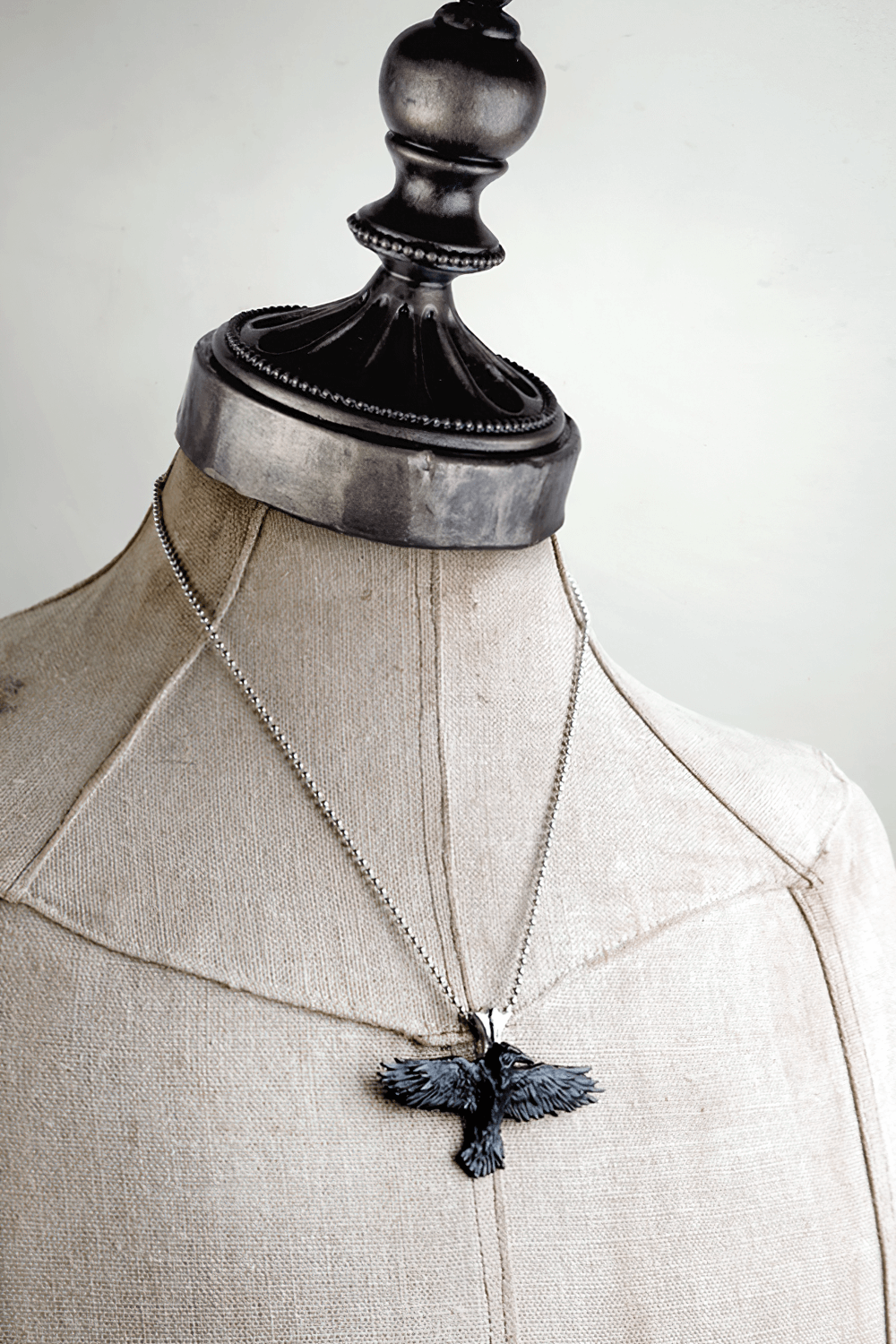 Gothic black raven pendant on a polished chain, showcasing dark fantasy style for alternative fashion lovers.