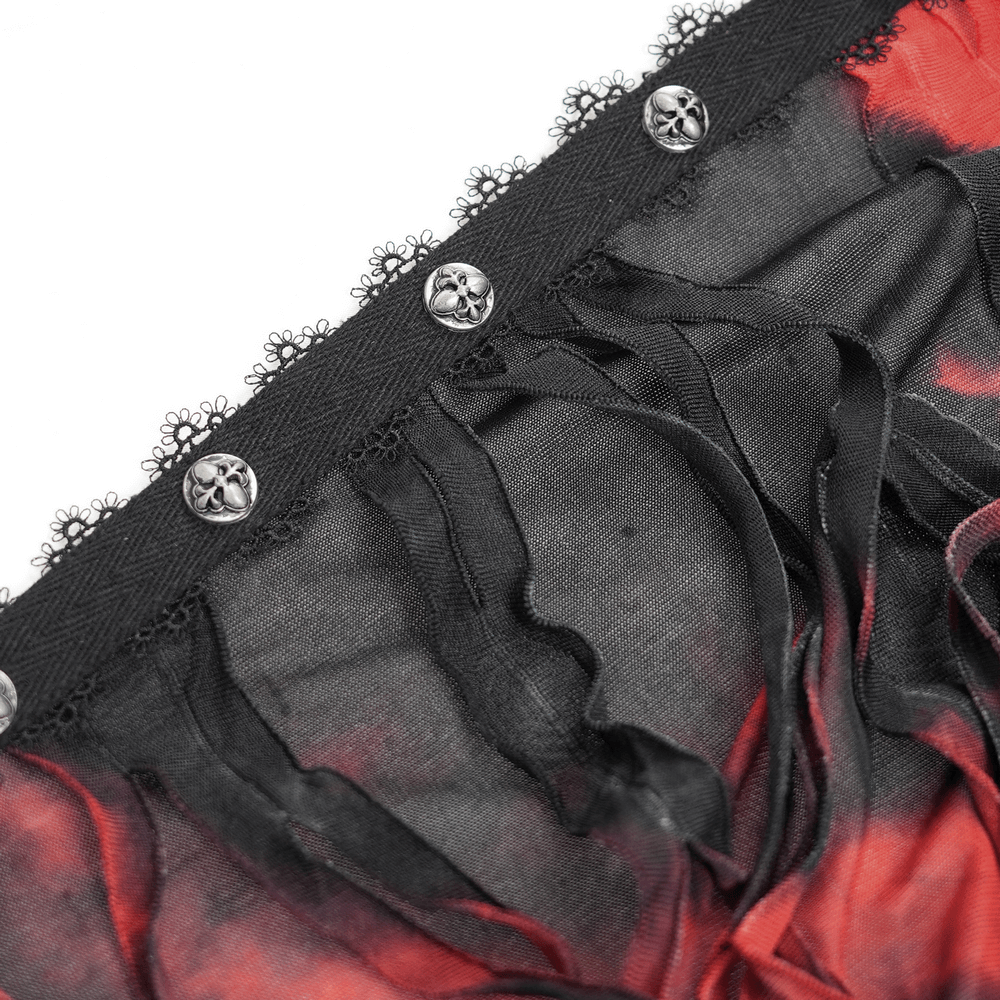 Close-up of gothic red and black lace-trimmed fabric with skull buttons and shredded details for a dramatic look.