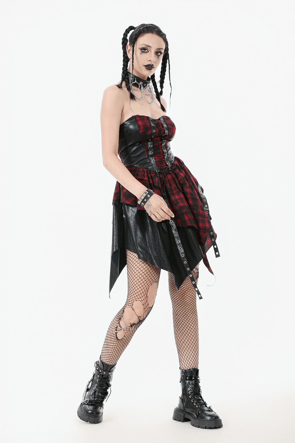 Gothic red plaid and leather dress with lace-up details, worn by model with braided hair and fishnet tights.