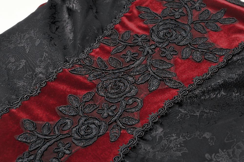 Close-up of black fabric with red velvet and intricate black lace floral detailing, perfect for gothic elegance.