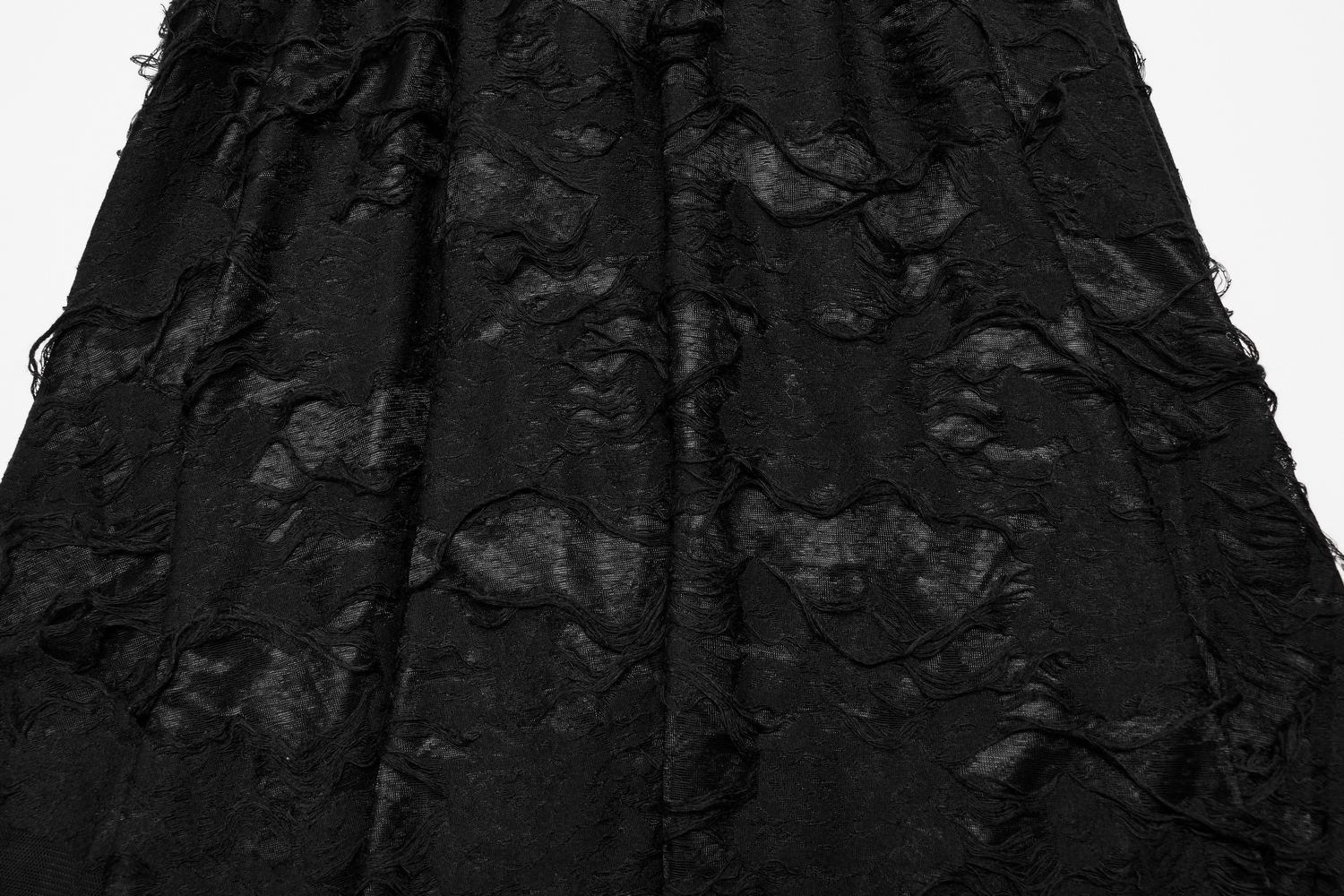 Close-up of a gothic black mesh skirt with a ripped texture, showcasing edgy layers and dramatic design.