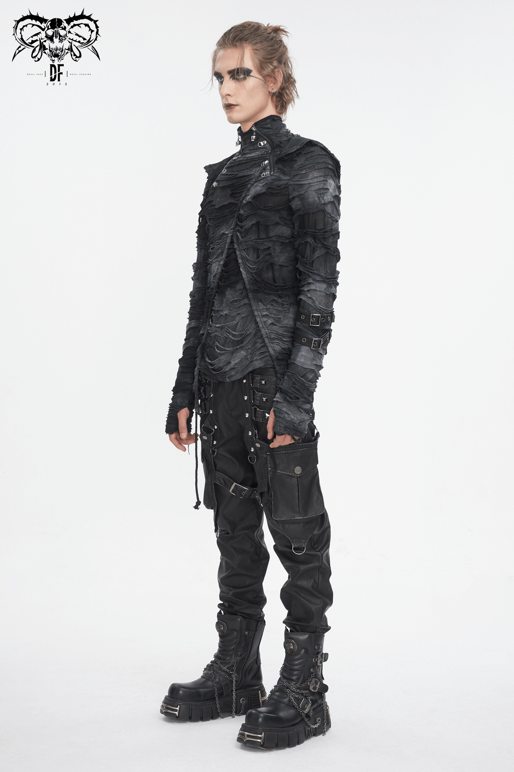 Edgy model wearing a gothic layered black hoodie with buckle straps and matching pants, showcasing alternative fashion.