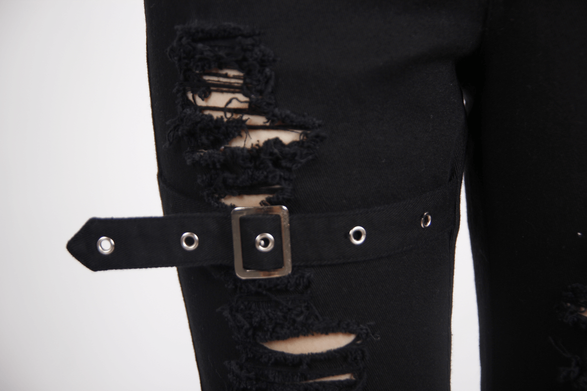 Close-up of gothic ripped pants featuring stylish buckle detail and distressed fabric for a trendy steampunk look.