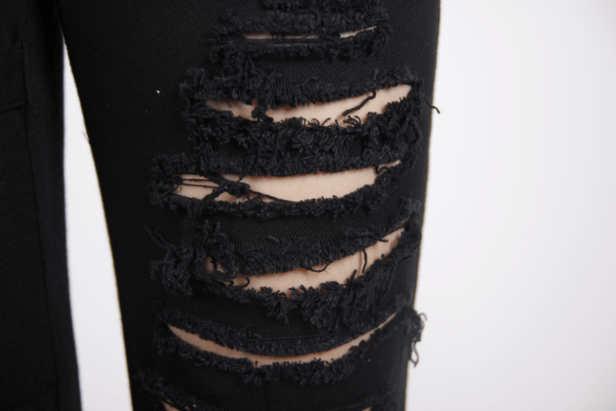 Close-up of gothic ripped black pants showing stylish torn inserts for a steampunk look.