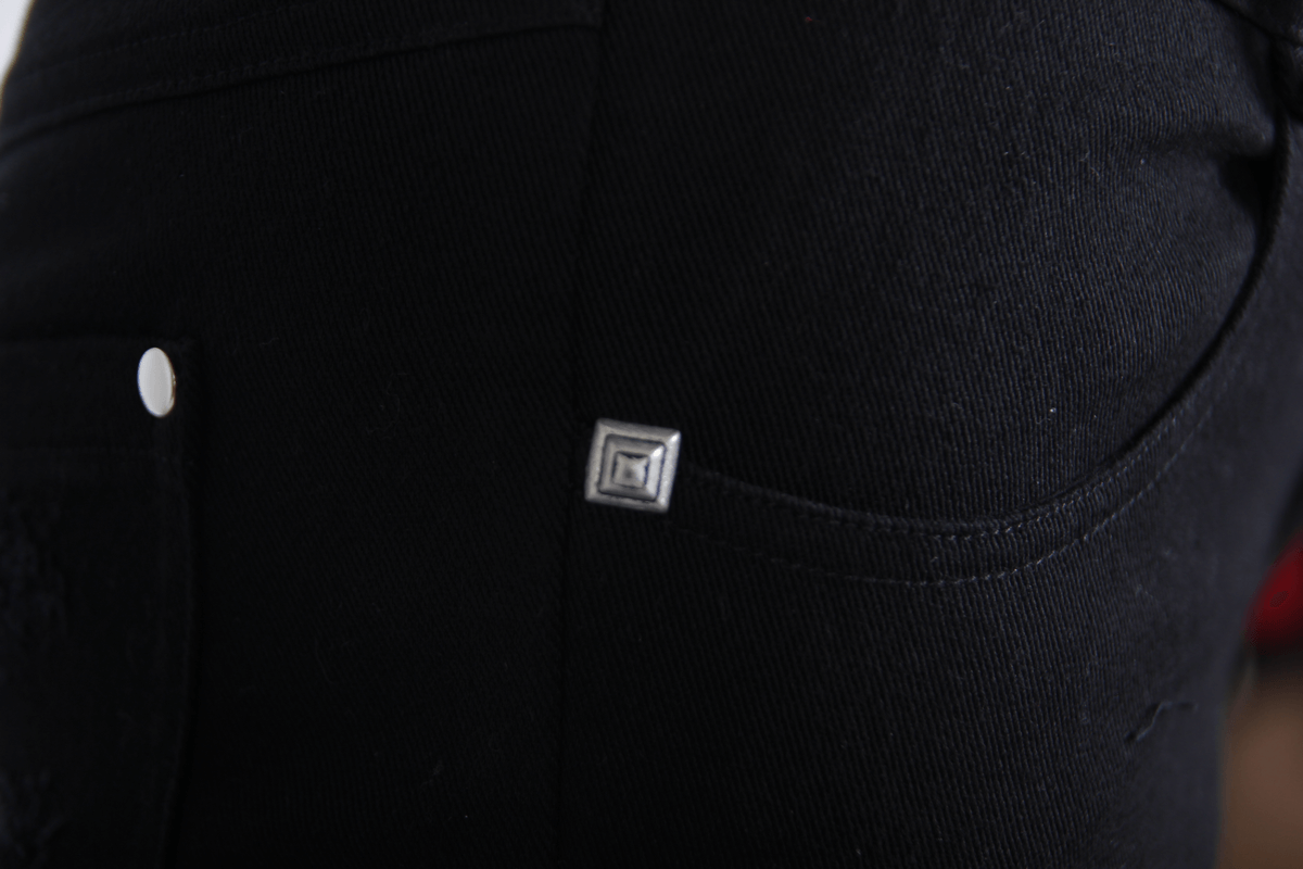 Close-up of gothic ripped black pants showcasing detailed stitching and stylish buckle accents.