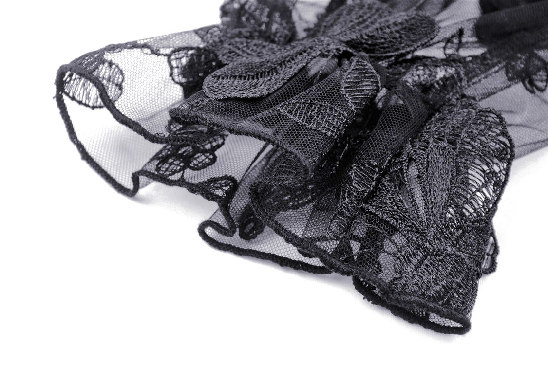 Close-up of delicate black lace fabric with intricate floral patterns and soft ruffles, perfect for gothic fashion.