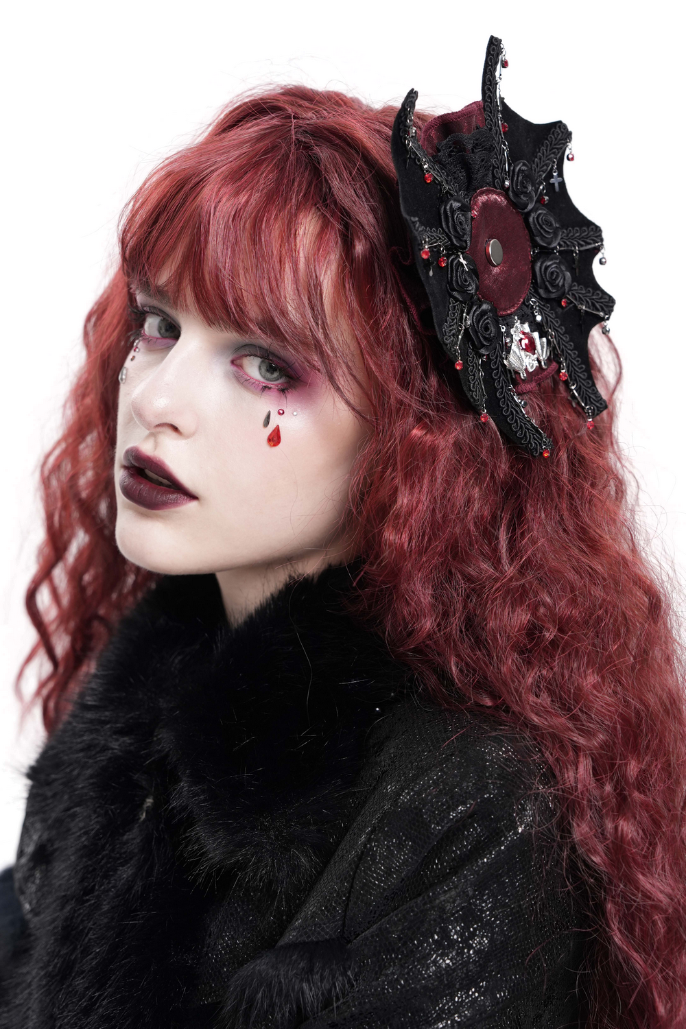 Gothic rose cross hair clip with spider web and skull detail, worn by model with red hair and dramatic makeup.