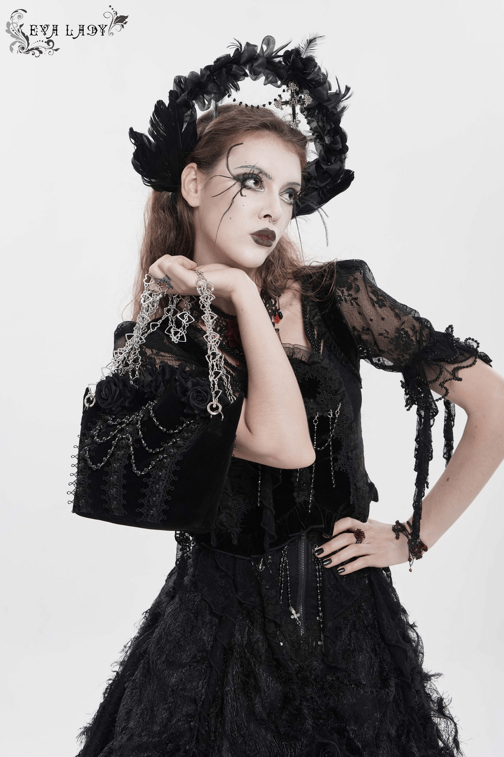 Alt Tag: Gothic Rose Velvet Handbag with Pearl Chains and Lace worn by model, black gothic shoulder bag with lace, bead chains and heart chain straps