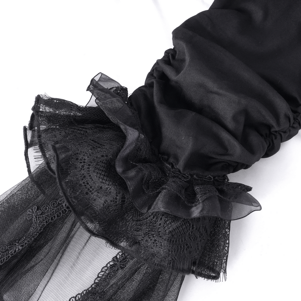 Close-up of gothic ruched pant hem with tulle and lace detailing, showcasing elegant black fabric and flared design.