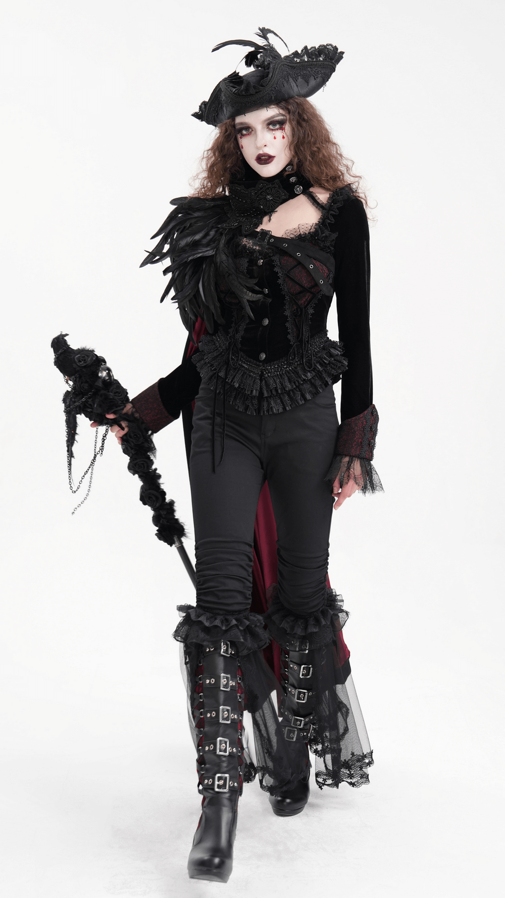 Gothic model in a dramatic outfit with feathers, lace, and a stylish hat, embodying alternative fashion vibes.