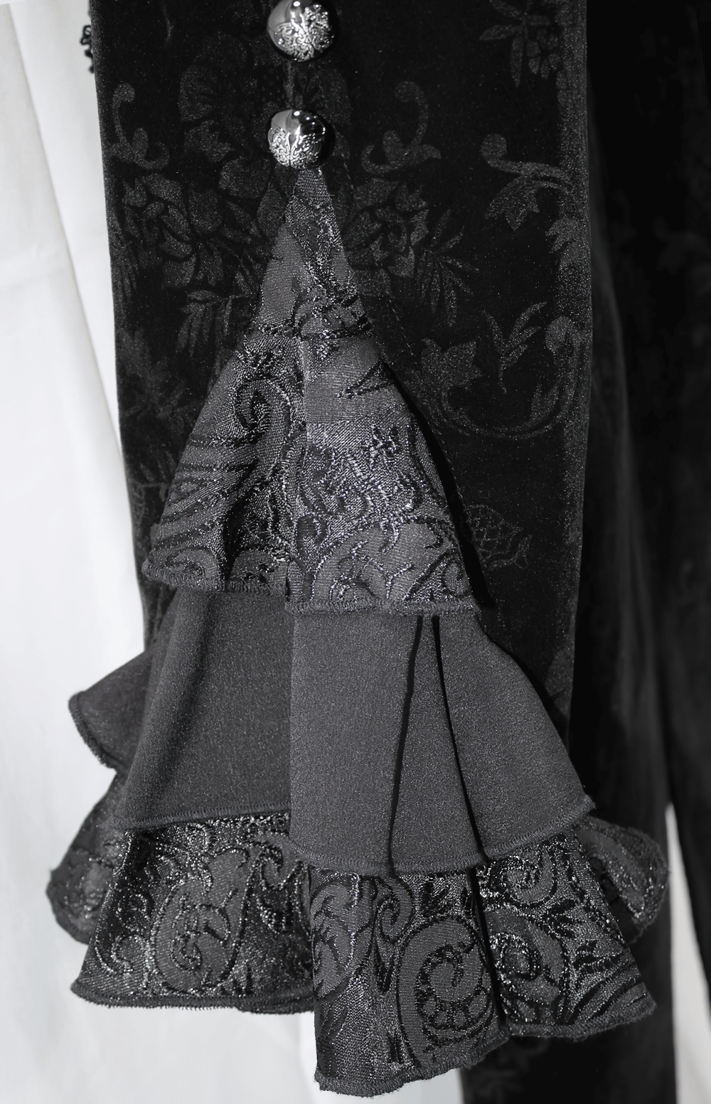 Close-up of Gothic Ruffle Jacket showcasing lace sleeves and delicate floral patterns in black fabric.