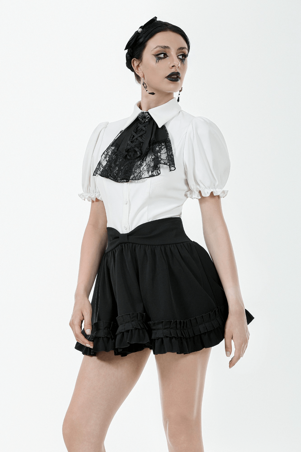 Model wearing a Gothic ruffle mini skirt with bow and satin layers, styled with a white blouse and lace details.