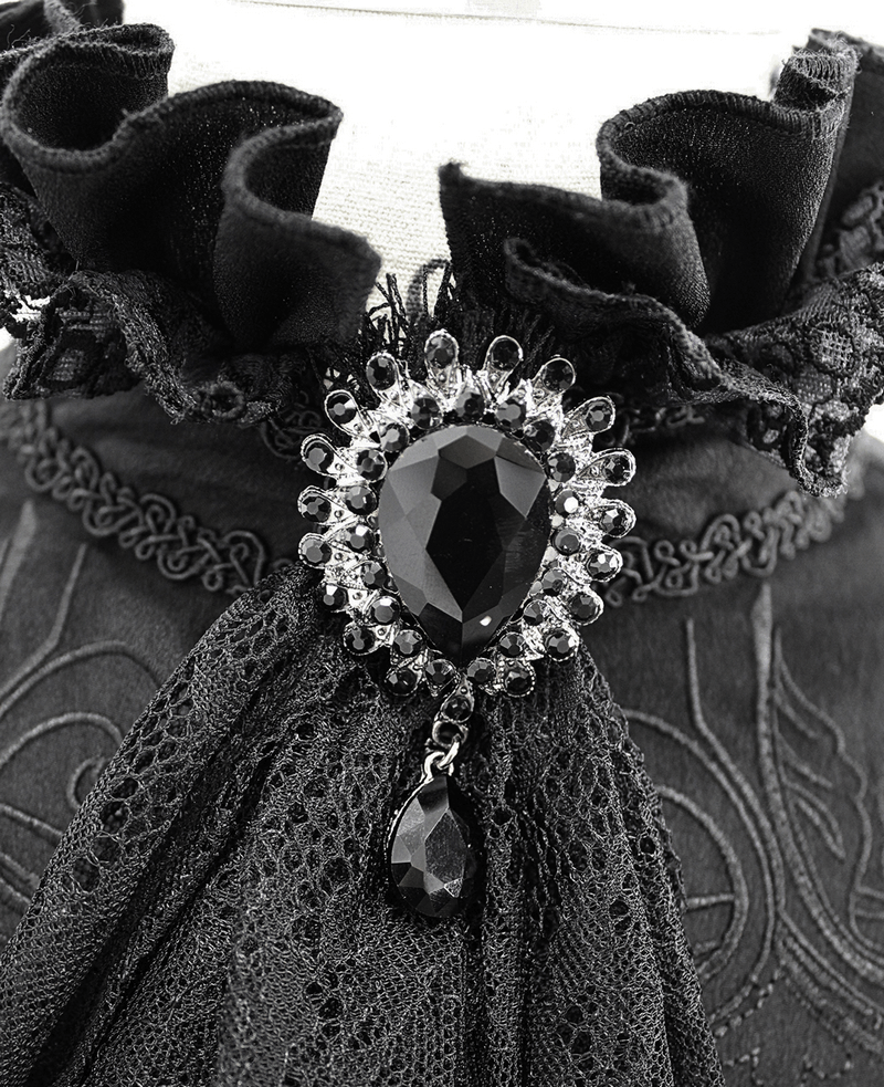 Close-up of a gothic black high collar shirt with ruffled lace detailing and a striking gemstone brooch.