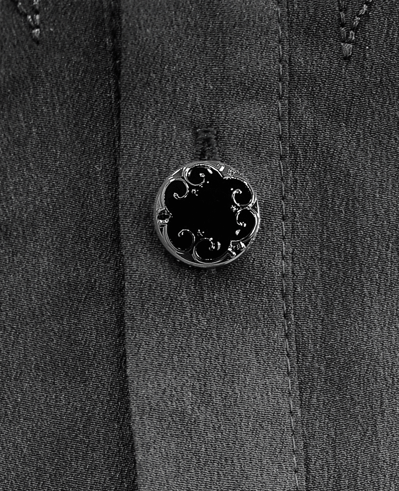 Close-up of a decorative black button on a gothic style shirt, showcasing intricate vintage design elements.