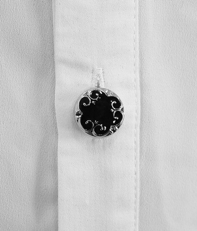 Close-up of a vintage black and silver decorative button on a white Gothic shirt, adding elegance to the design.