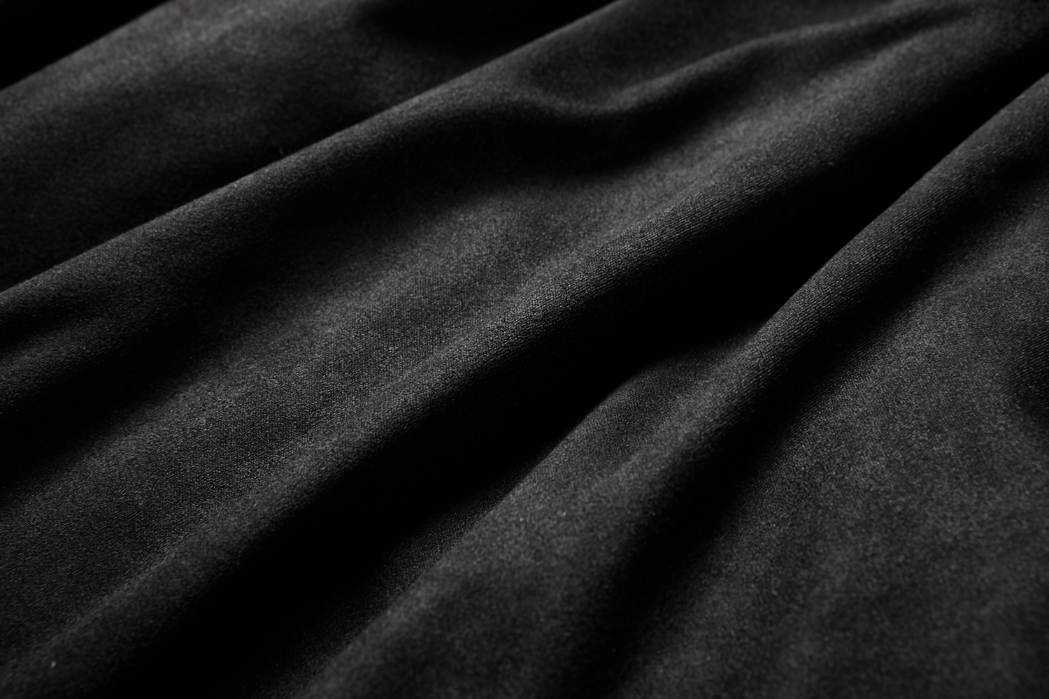 Close-up of luxurious black fabric showcasing soft, smooth texture, perfect for a gothic ruffled skirt.