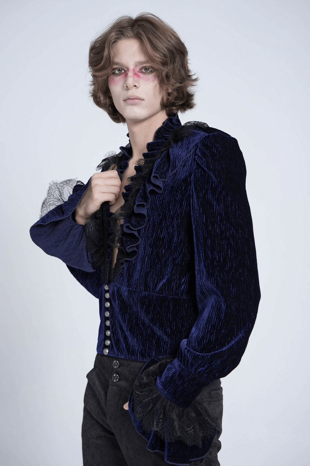 Model showcasing a Gothic ruffled velvet shirt with lace and pearl accents in deep blue.
