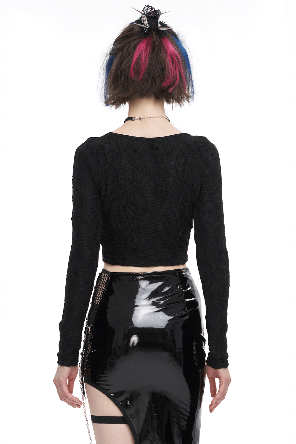 Gothic long-sleeved black crop top with textured design, paired with a shiny black skirt, showcasing edgy fashion.
