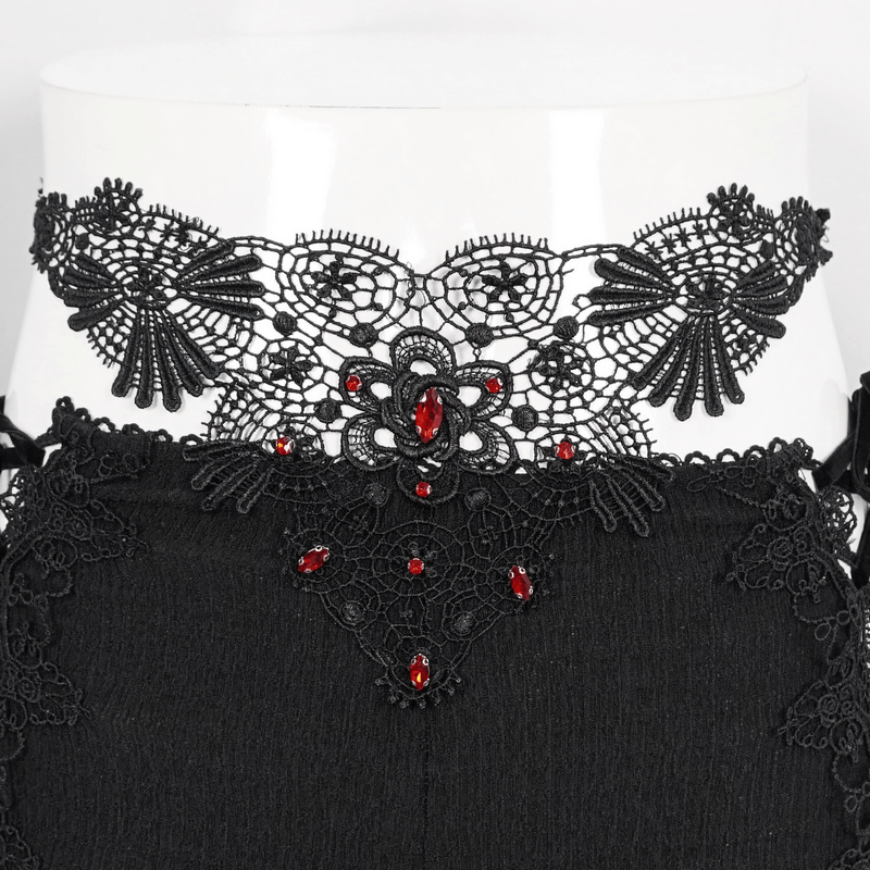 Close-up of intricate black lace with red embellishments on women's gothic trousers, showcasing vintage elegance.