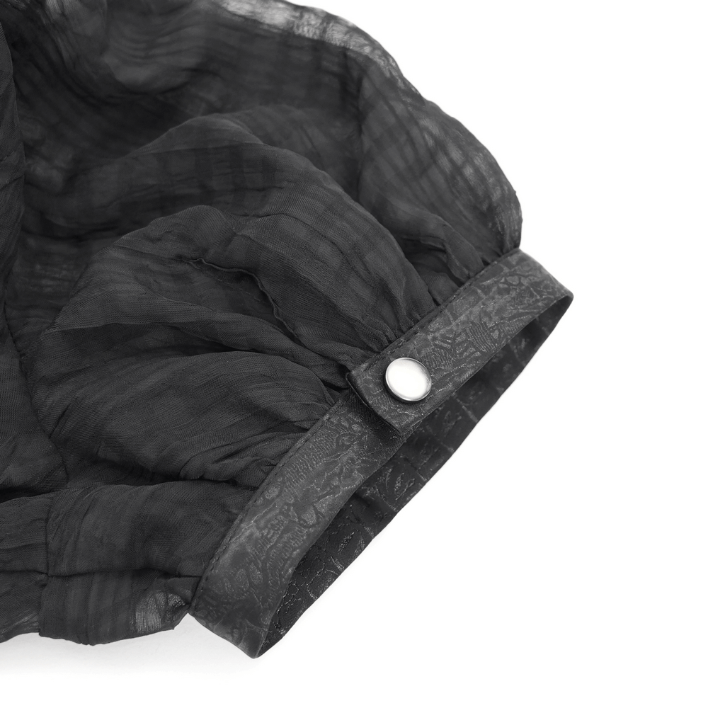 Close-up of gothic sheer black blouse sleeve with puff detail and button, showcasing dark punk fashion style.