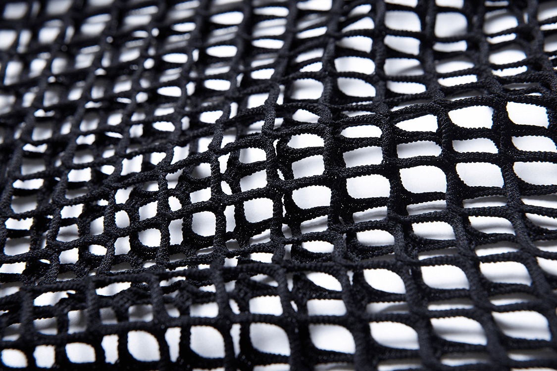 Close-up of black sheer mesh fabric, perfect for gothic fashion and edgy styles.