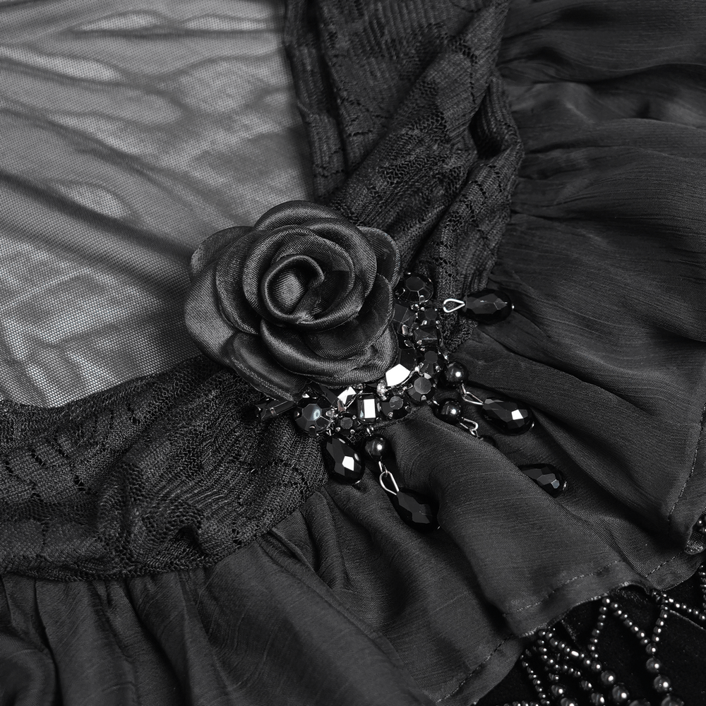 Close-up of gothic sheer mesh shrug with ruffles, lace, and beaded embellishments, featuring a decorative rose.