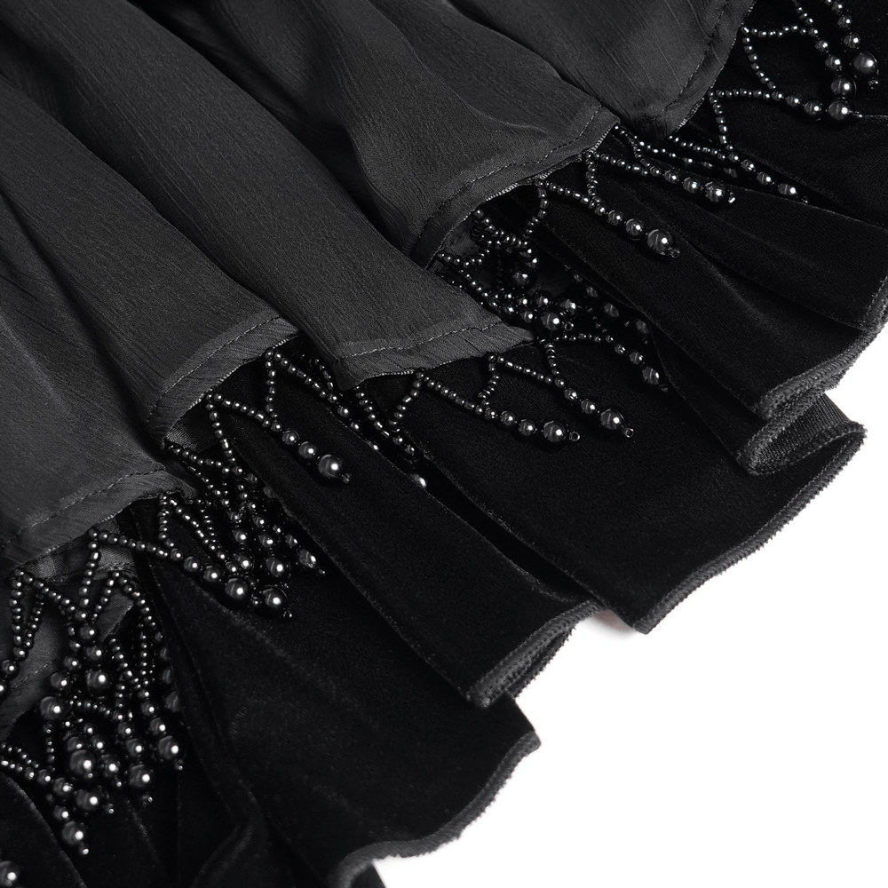Close-up of black sheer mesh shrug with intricate beaded fringe and ruffled trim, showcasing gothic elegance.