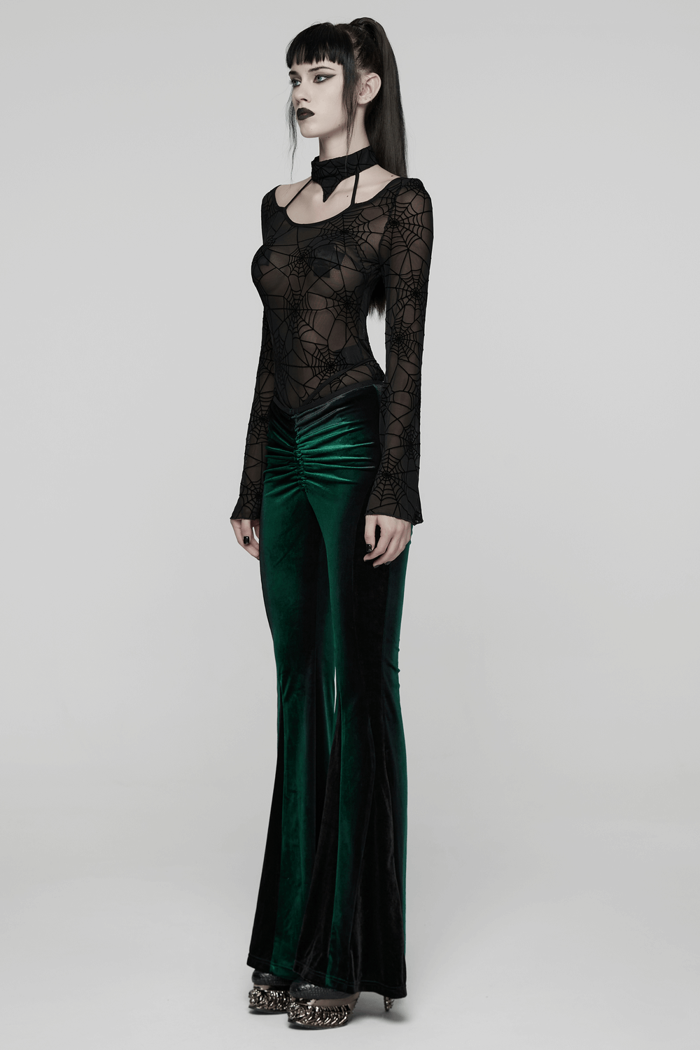 Gothic Sheer Mesh Spider Web Long-Sleeved Top styled with a striking green velvet skirt, exuding dark Gothic elegance.