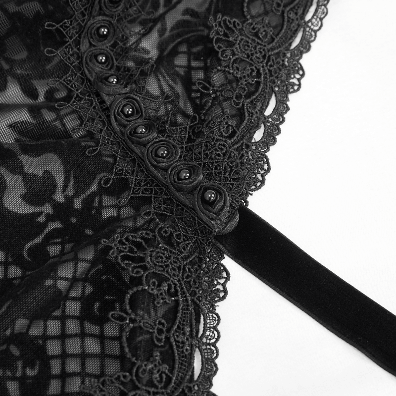 Close-up of elegant black lace detailing on gothic women's cape with floral mesh and buttons.