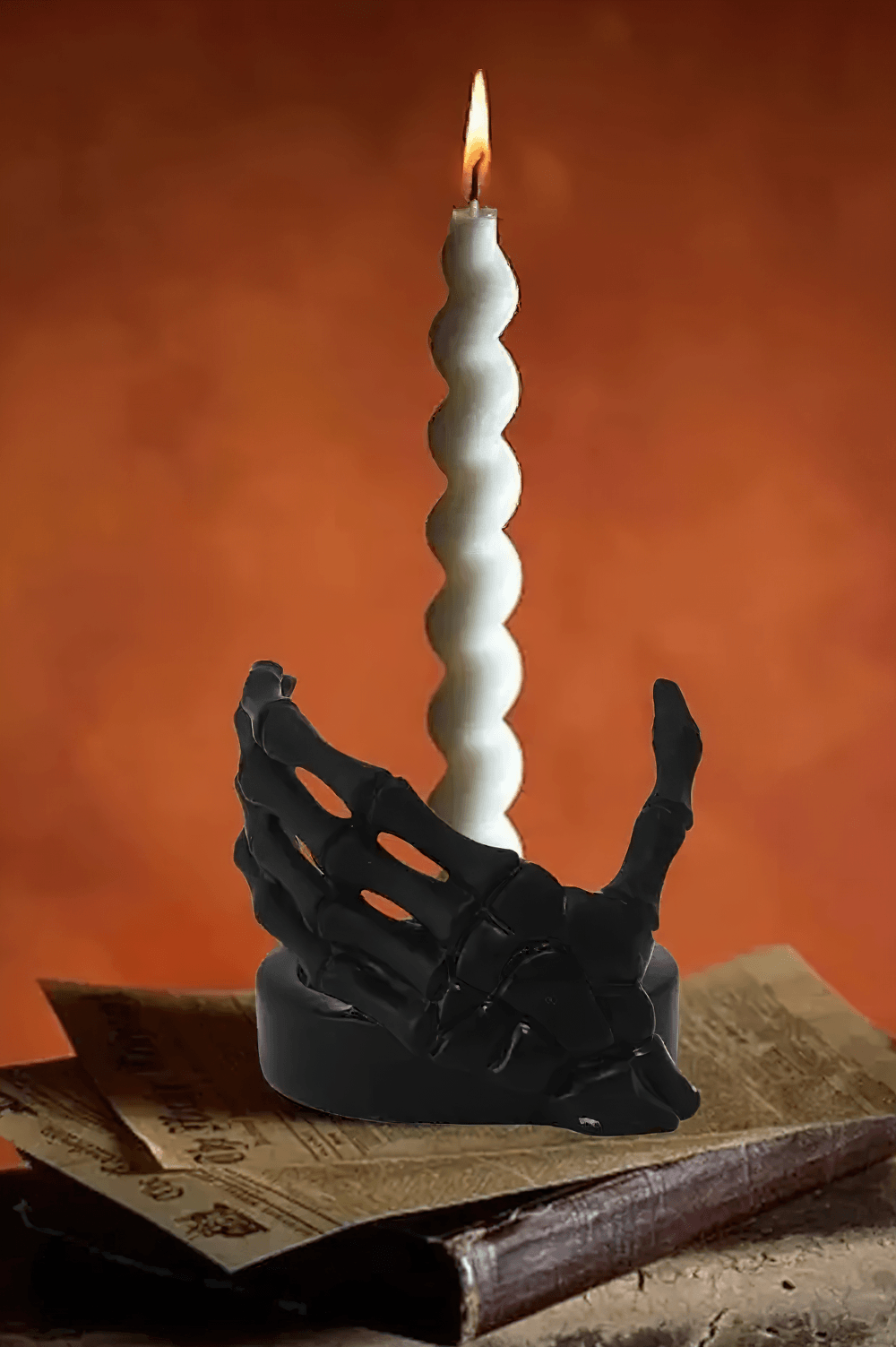 Gothic Skeletal Hand Candle Holder for Dark Decor with a black bone hand cradling a twisting white candle.