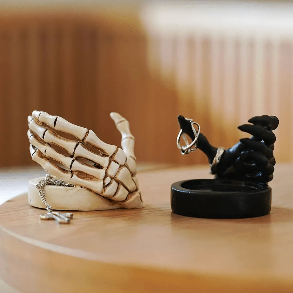 Gothic Skeletal Hand Candle Holder for Dark Decor showcasing a bone hand and black skeletal hand on a wooden table.