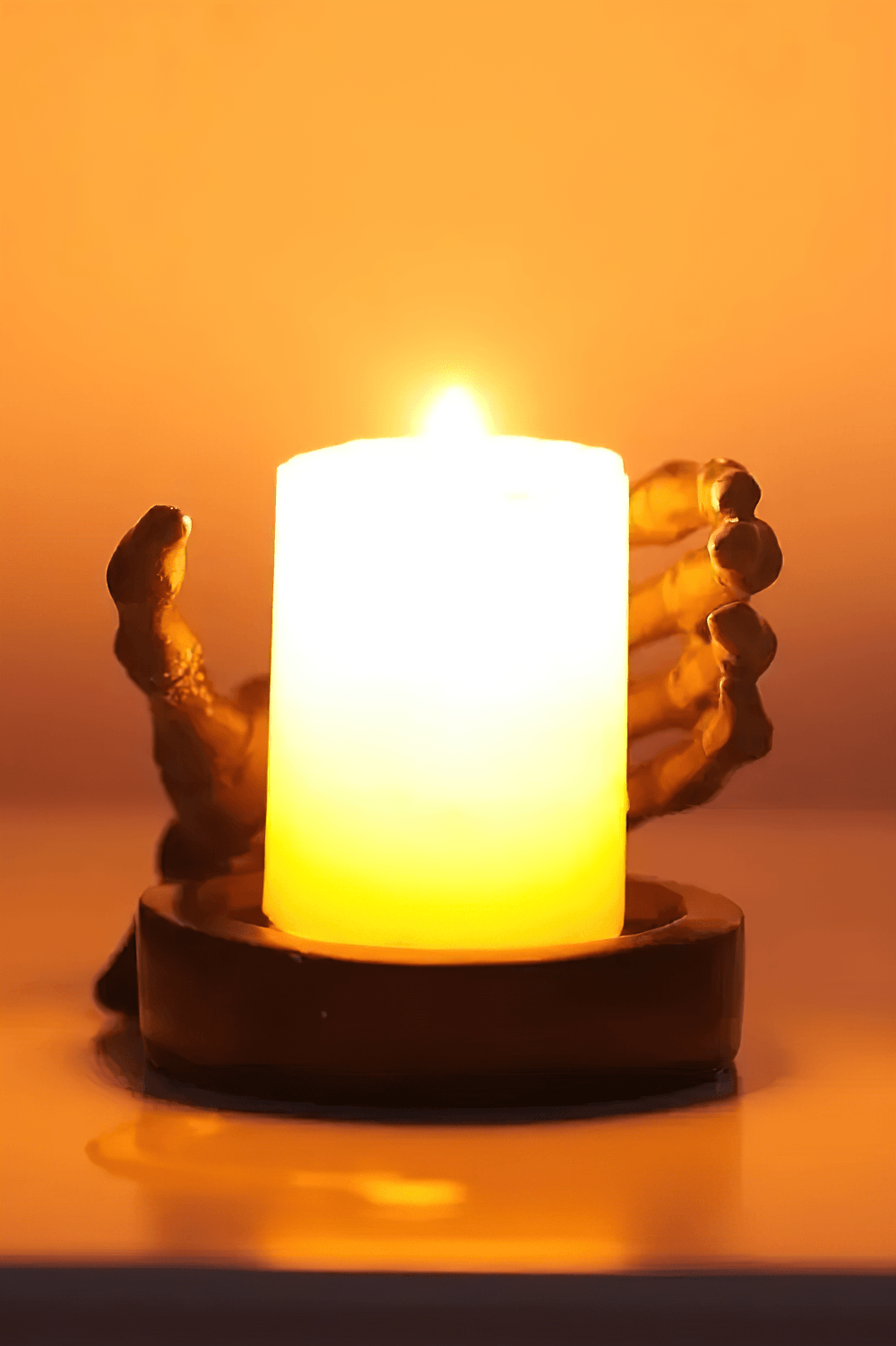 Gothic Skeletal Hand Candle Holder for Dark Decor with a glowing candle in a spooky skeleton hand.