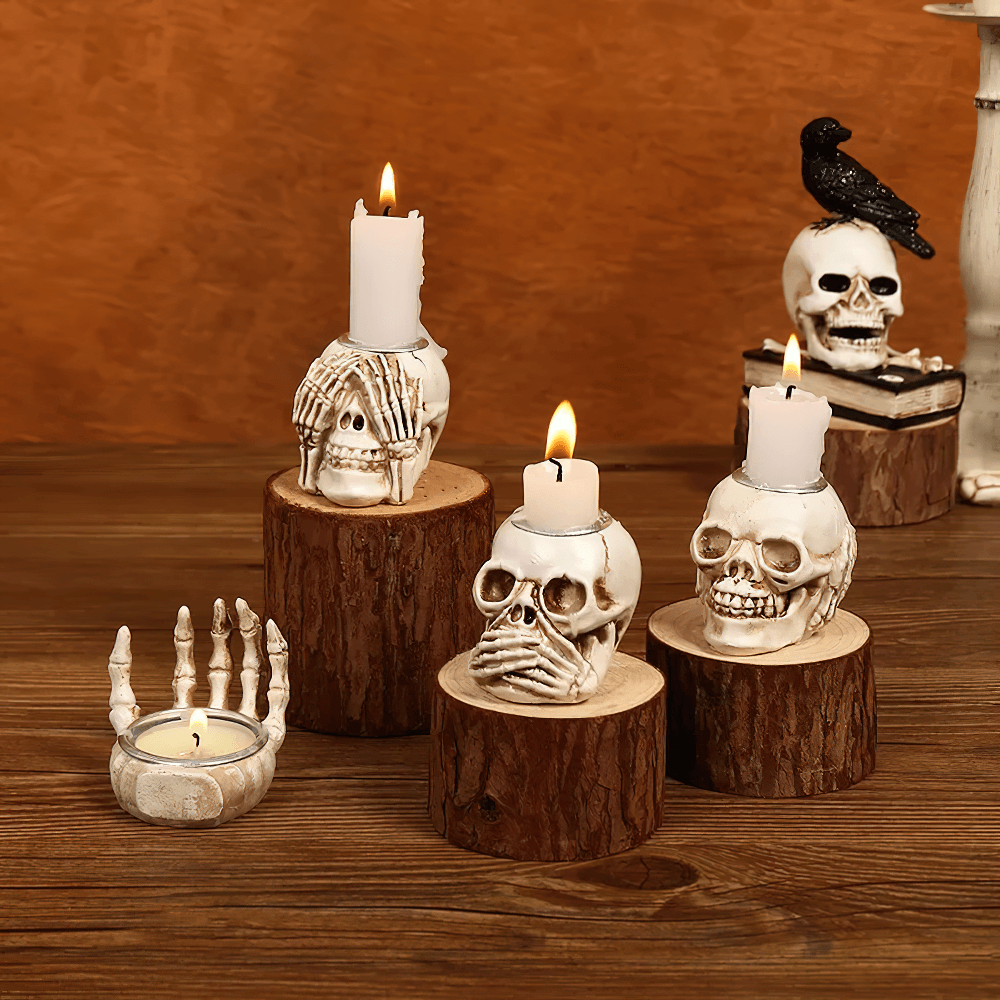 Spooky Gothic candle holders shaped like skulls and hands on wooden bases for Halloween decor.