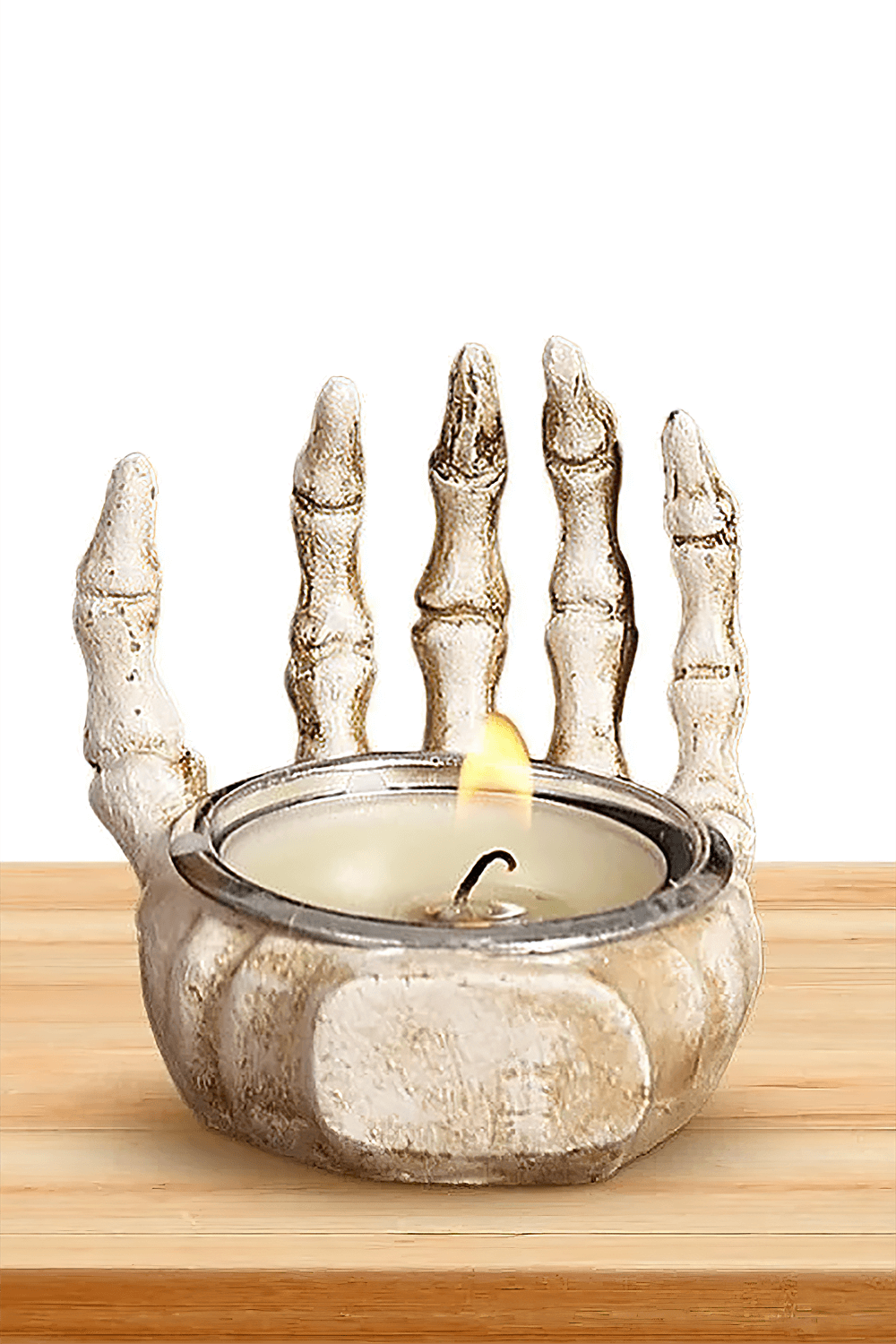 Gothic skeleton hand candle holder with tea light for Halloween decor, spooky resin design on wooden table.