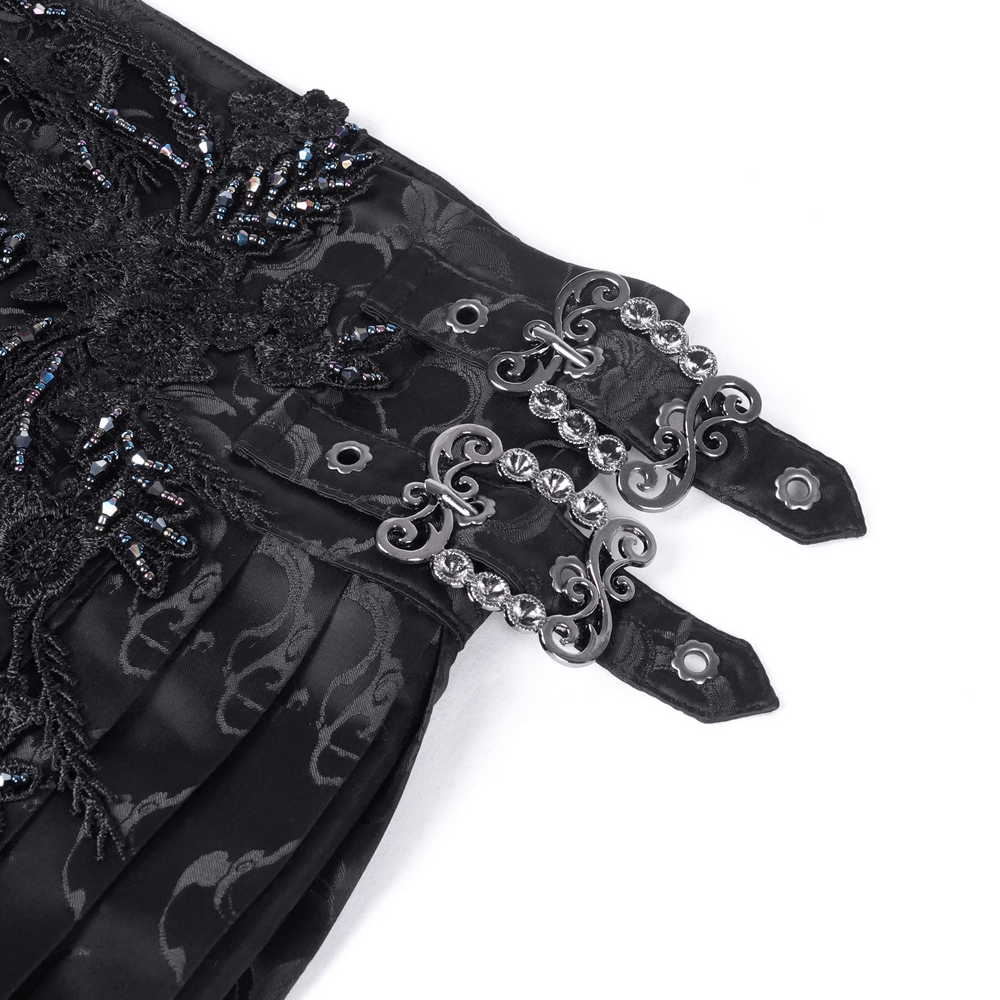Close-up of black gothic skirt embellishments with intricate embroidery and ornate silver clasps.
