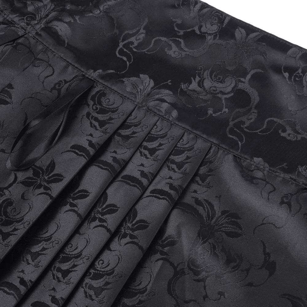 Close-up of a flowing black skirt with intricate floral embroidery and pleated details for a gothic vibe.