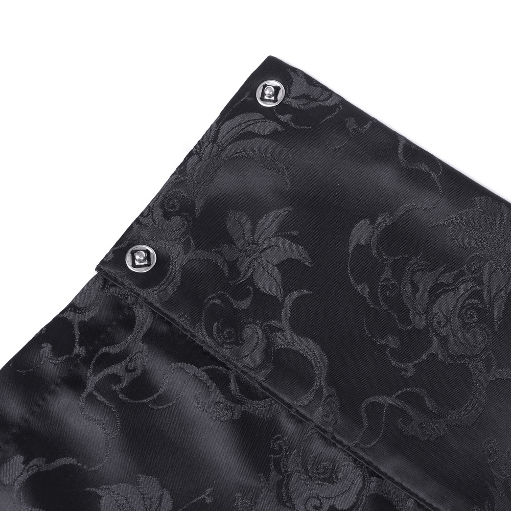 Close-up of the elegant black fabric with floral embroidery and embellished buttons.