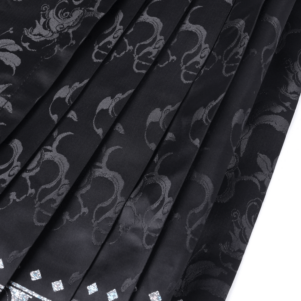Close-up of a flowing black skirt with intricate silver embroidery and elegant embellishments.